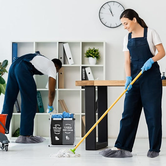 Black foldable laundry basket on the floor of a room while a person mops