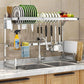 Large stainless steel over-sink dish drying rack holding plates, bowls and utensils above a kitchen sink