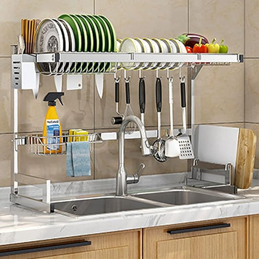 Large stainless steel over-sink dish drying rack holding plates, bowls and utensils above a kitchen sink